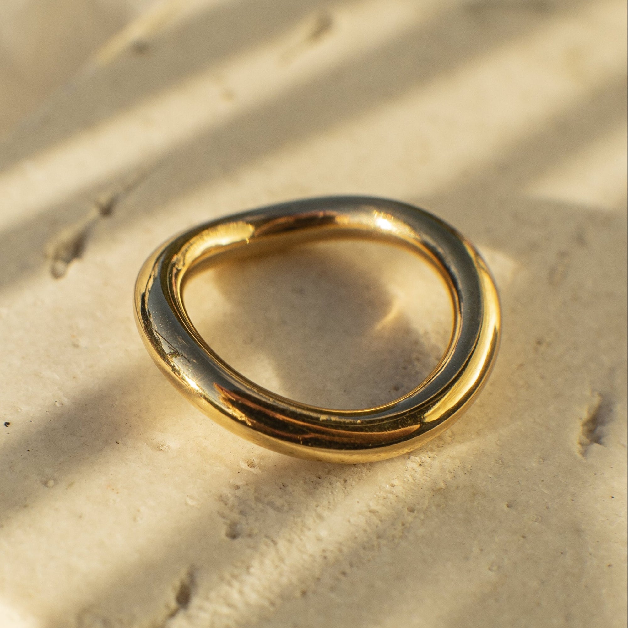 Gold ring on a textured beige surface