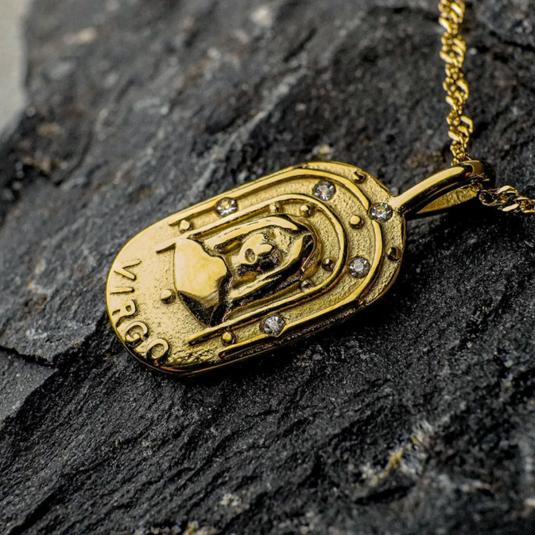 Gold Virgo Zodiac Sign pendant on a dark stone surface