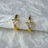 Gold triangle-shaped earrings on a textured white surface