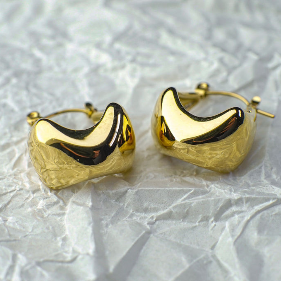 Pair of gold hoop earrings on a textured white background