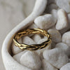 Gold braided ring on white pebbles