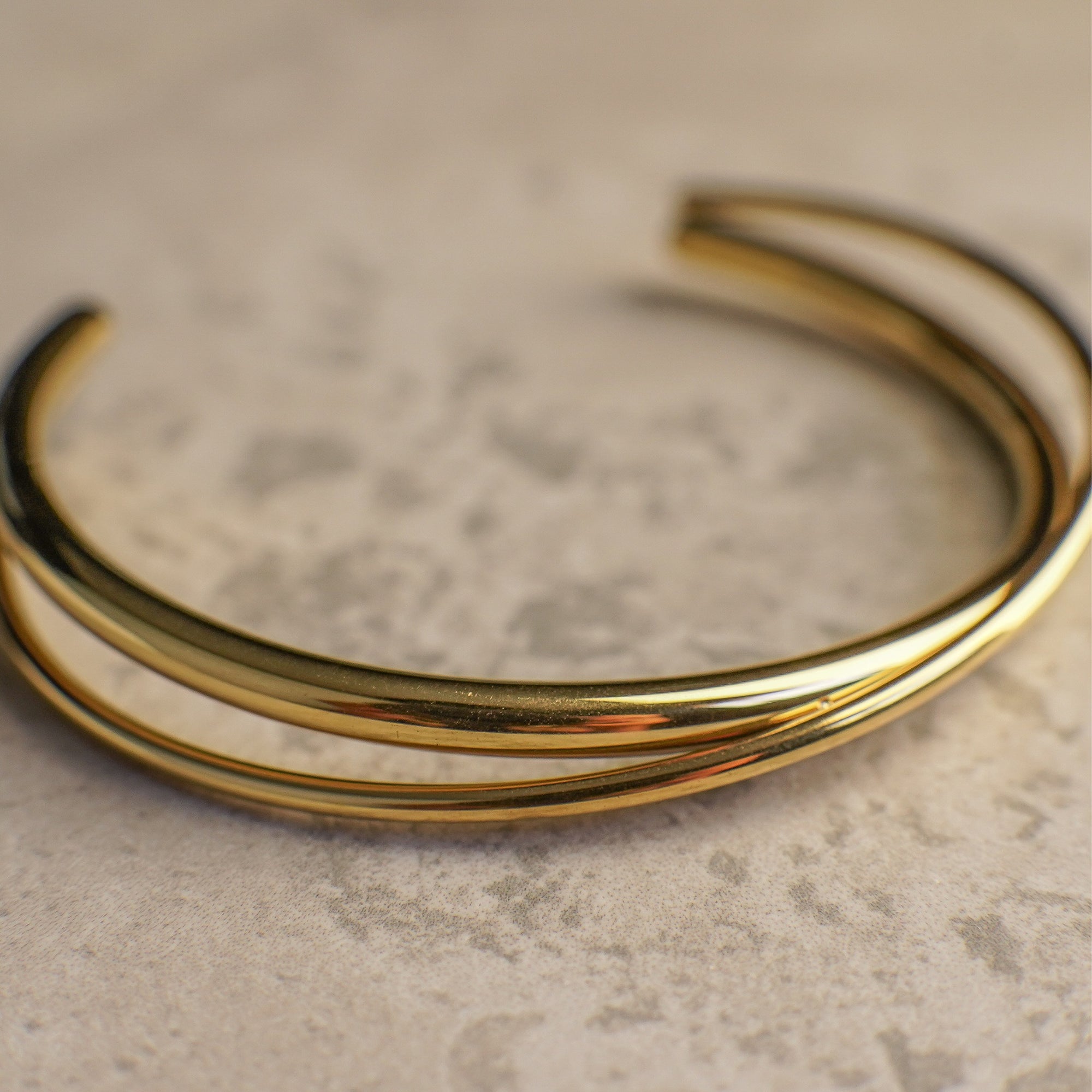 Gold twisted bracelet on a textured surface