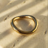 Gold ring on a textured beige surface