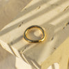 Gold ring on a textured beige surface