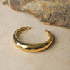 Gold bracelet on a textured stone surface