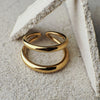 Two gold rings stacked on a textured stone surface