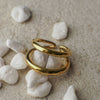 Gold ring on white pebbles with a natural background