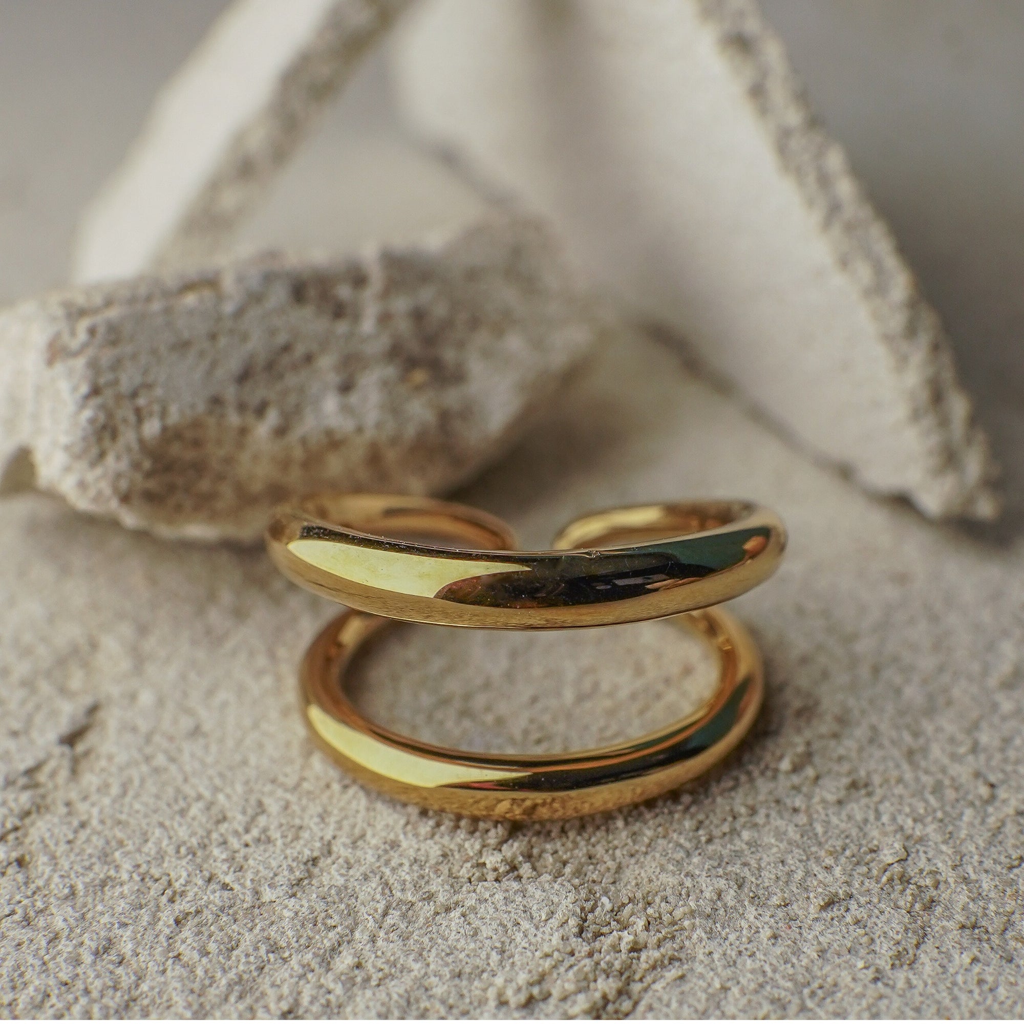 Gold ring on a textured surface with a neutral background