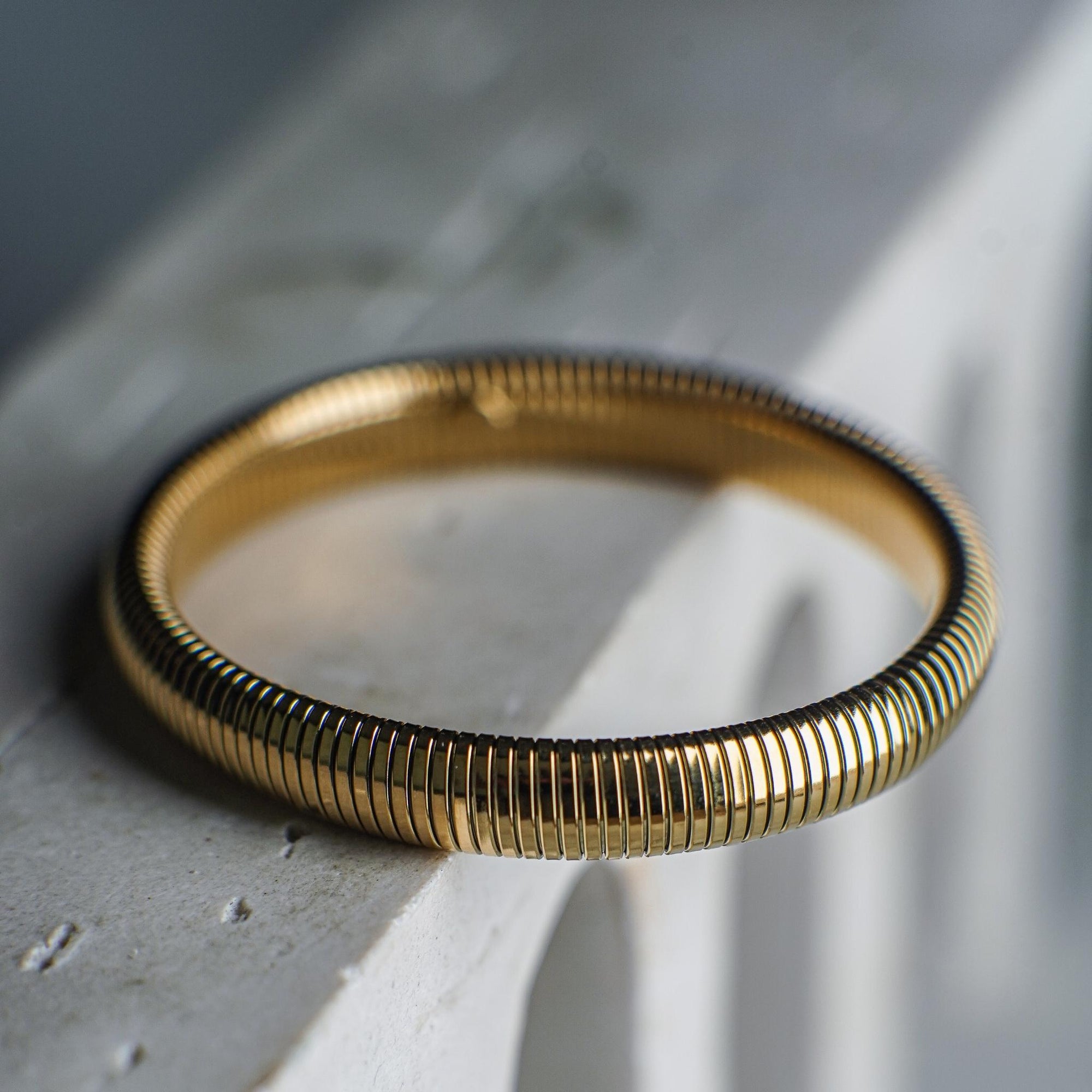 Gold bracelet on a textured surface