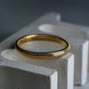 Gold ring on a textured white surface with a blurred background