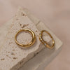 Two gold rings; one is plain, and one has zirconia 