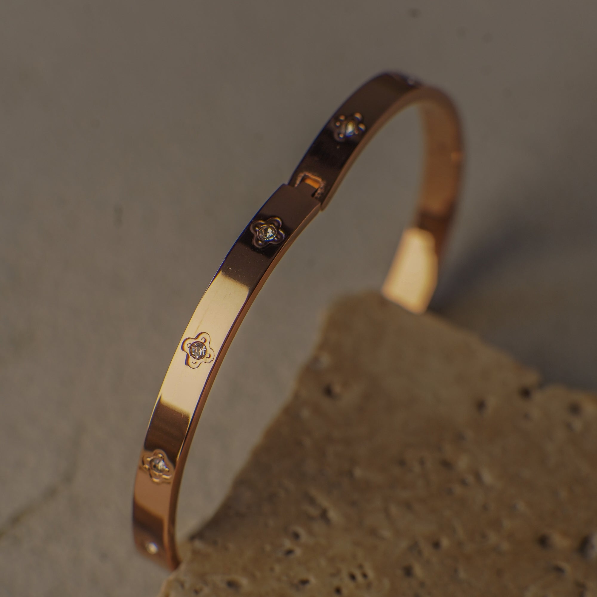 Rose gold bracelet with small diamonds on a textured surface