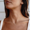 A model wearing gold necklace with cubic zirconia pendant