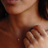 A model wearing a gold necklace with rose quartz pendant paired with the ring with the same features