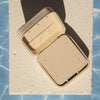 Beige jewellery case on a textured surface with blue pattern