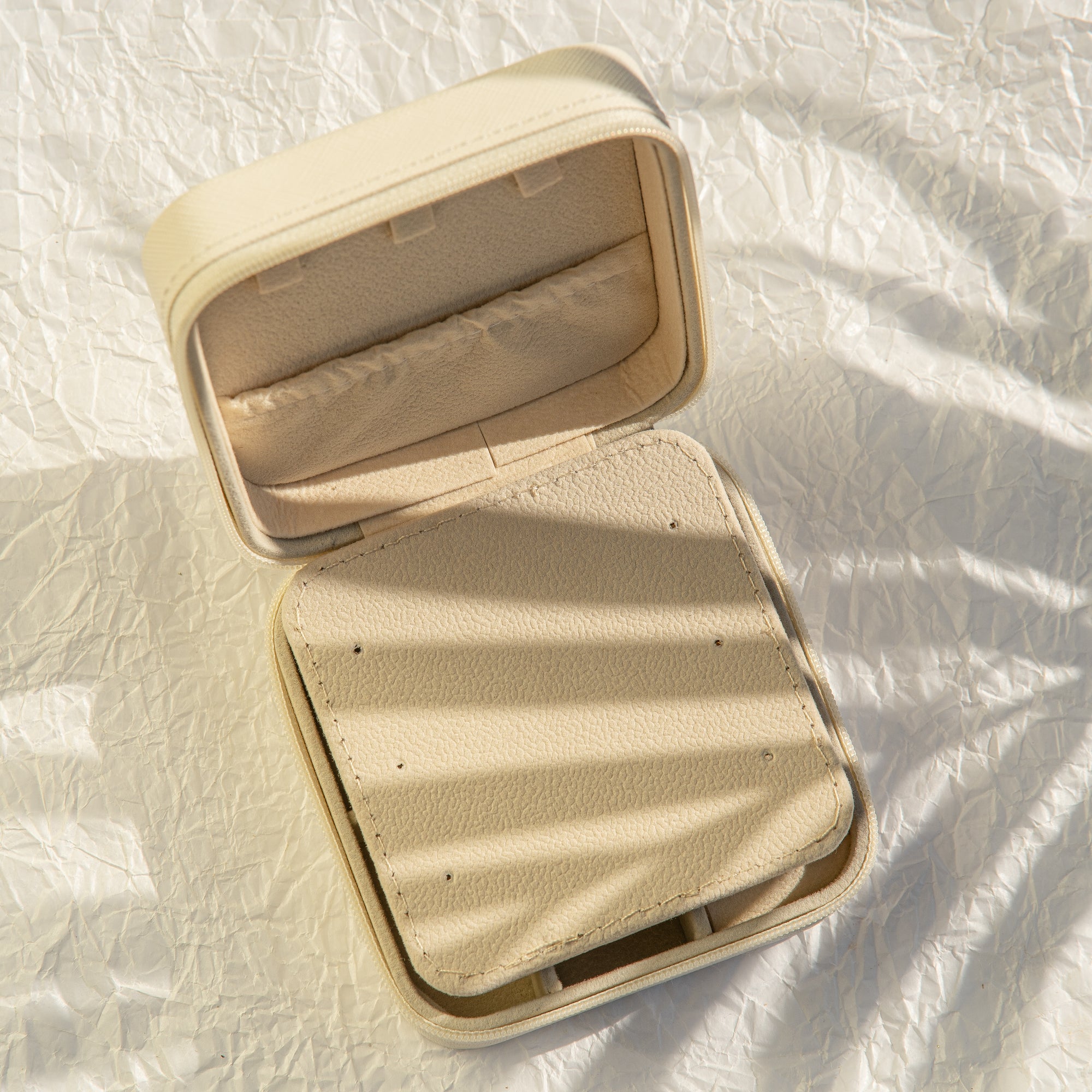 Beige jewellery case on a textured white surface
