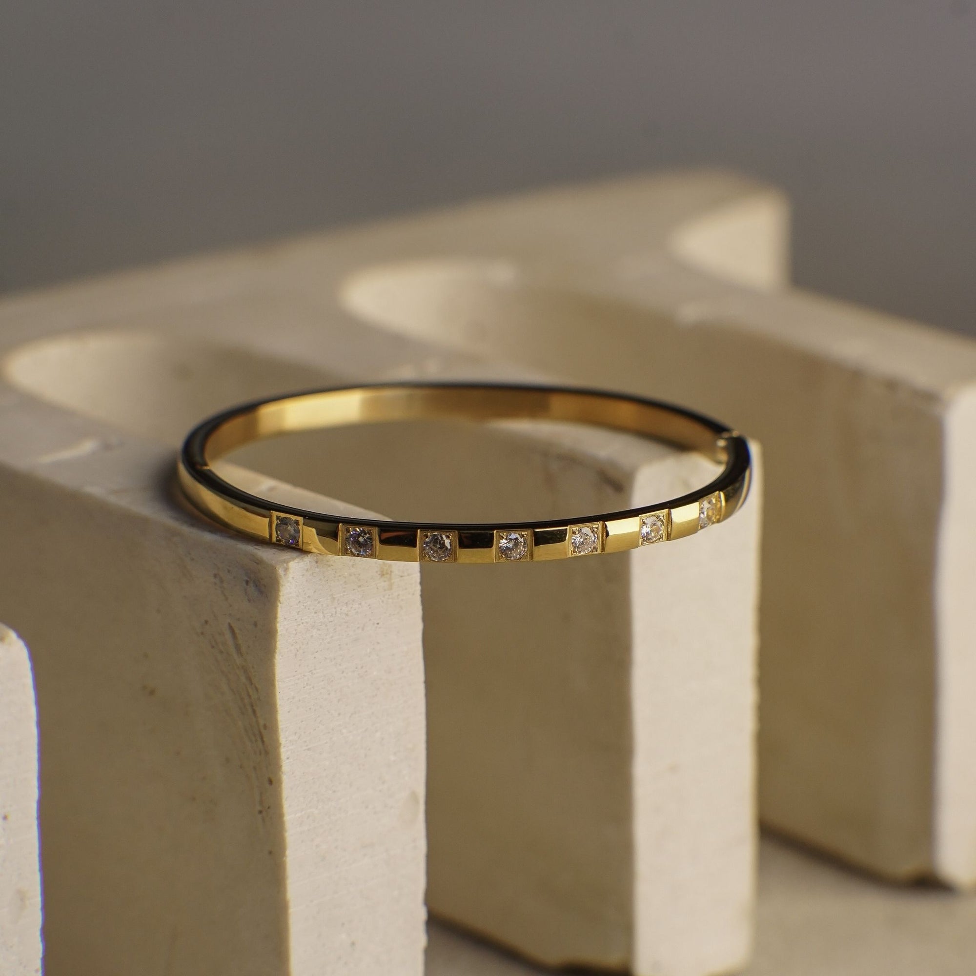 Gold bracelet with small diamonds on a textured surface