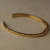 Gold bracelet with small diamonds on a beige background