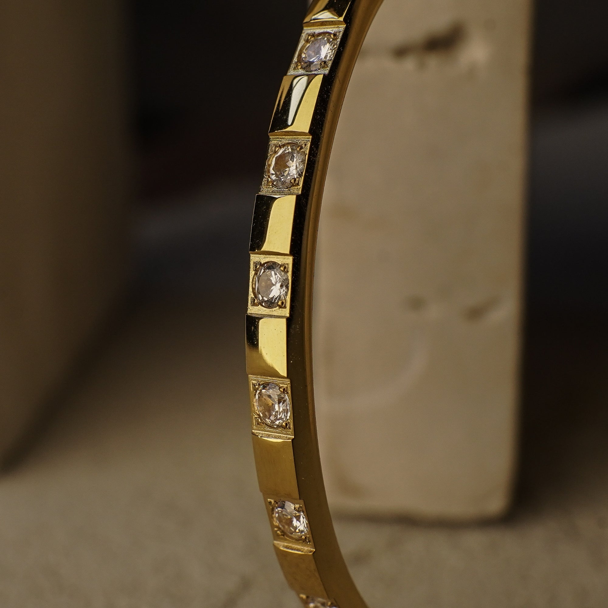 Gold bracelet with diamond accents on a textured surface