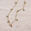 Gold necklace with small diamonds on a light wooden surface