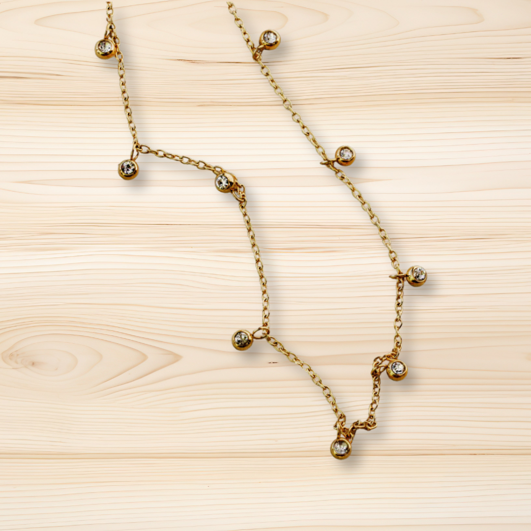 Gold necklace with small diamonds on a wooden surface