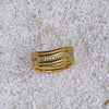 Gold ring with embedded diamonds on a textured beige surface