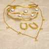 Gold jewelry set with pearls on a beige textured background
