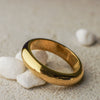 Gold ring on a sandy surface with pebbles