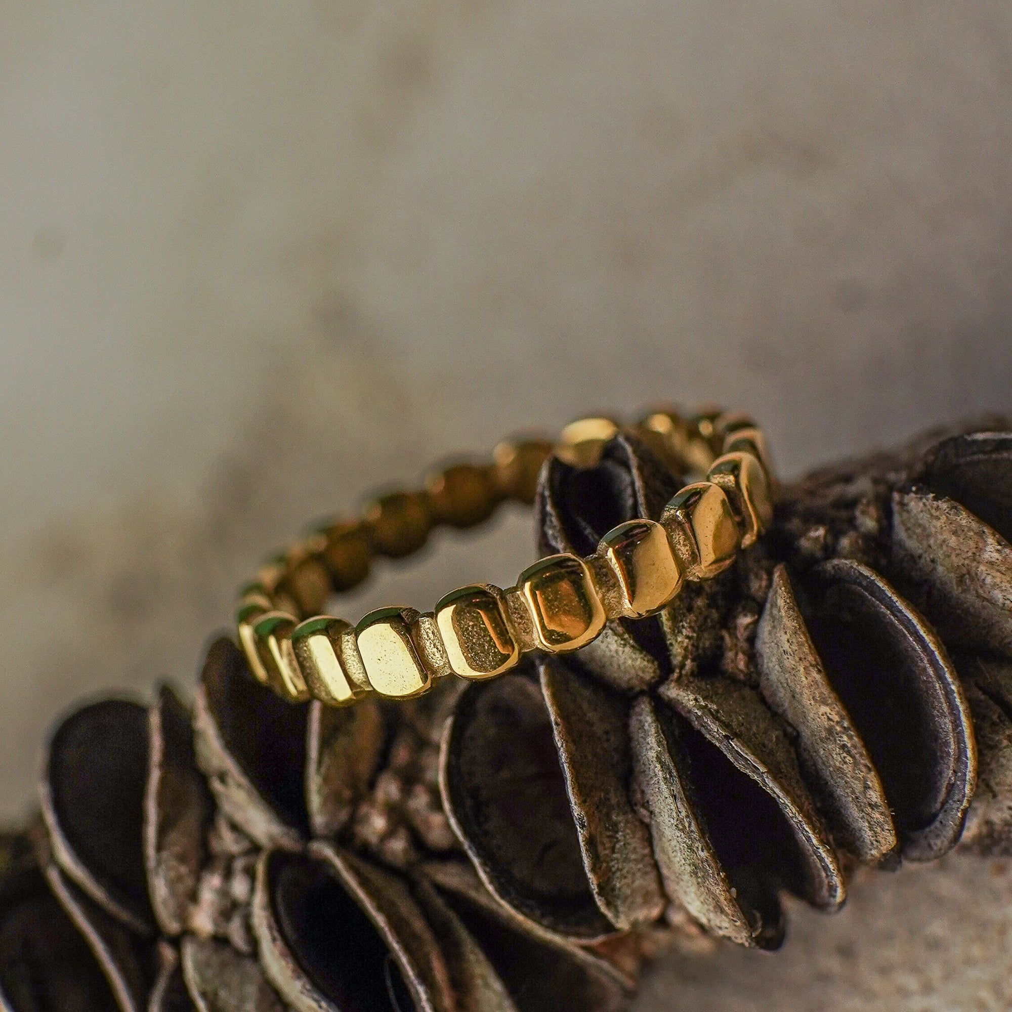 Gold bracelet on a textured surface with a neutral background