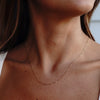 A model wearing a gold loop-de-loop chain necklace