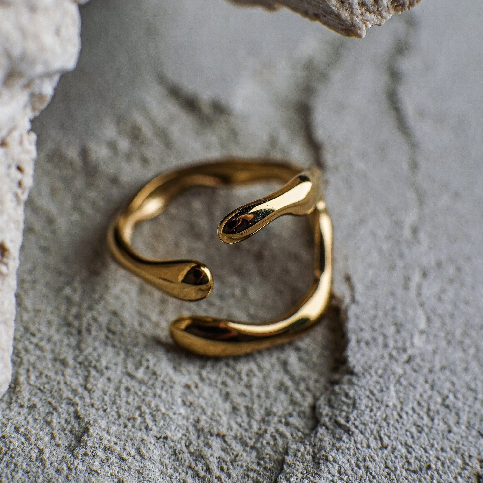 Gold open ring on a textured stone surface