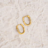 Gold hoop earrings on a light marble surface