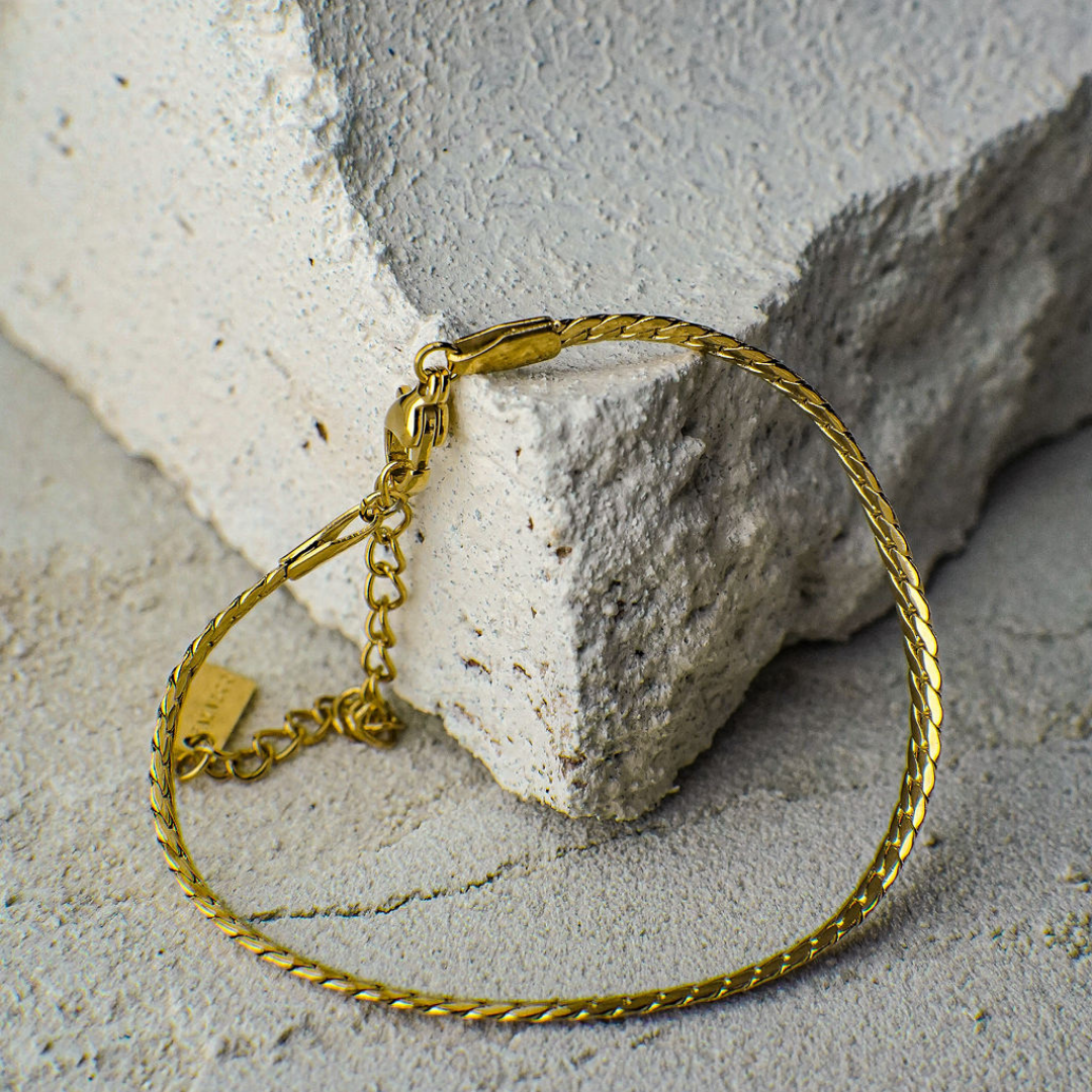 Gold bracelet on a textured stone surface