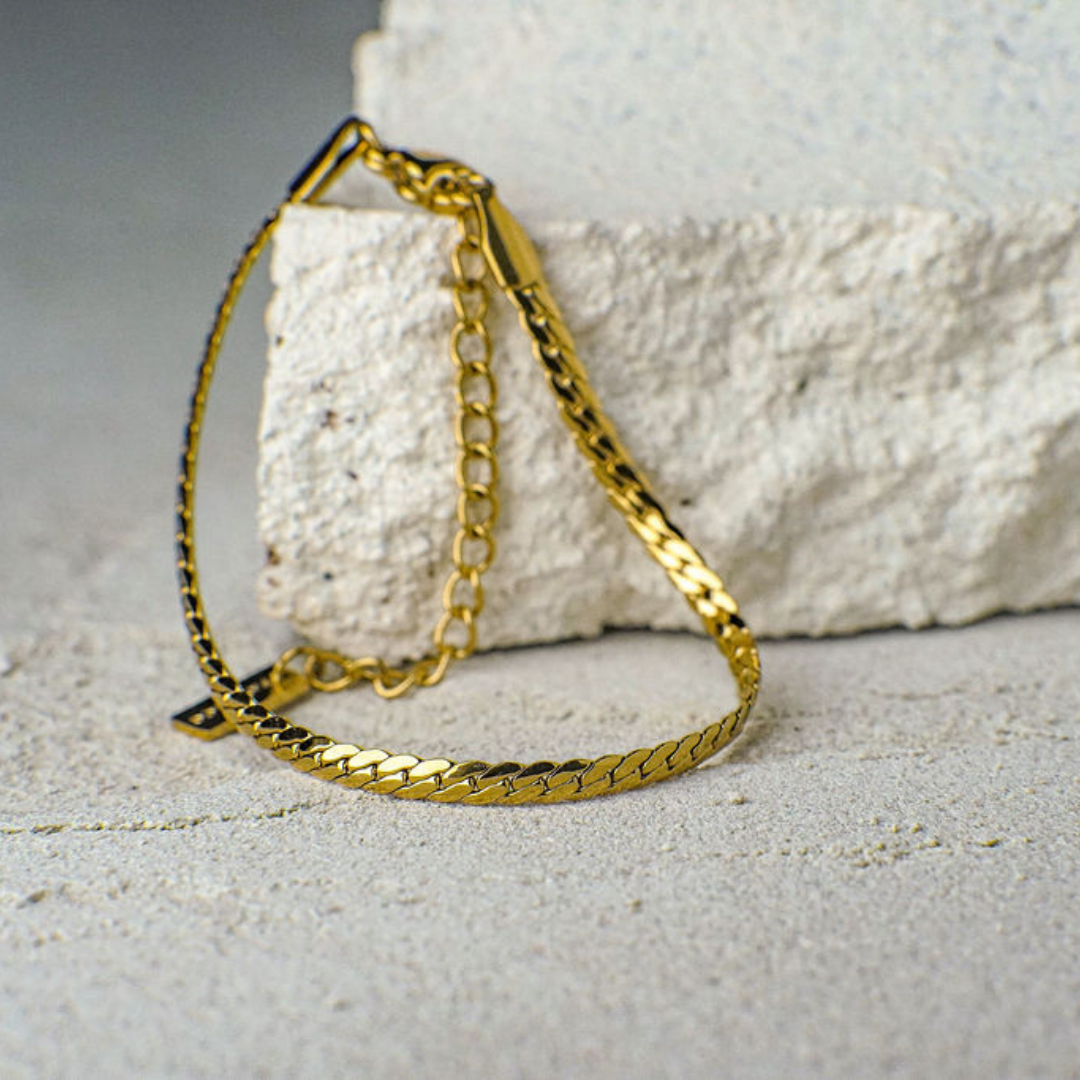 Gold chain bracelet on a textured surface