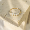 Gold ring with pearls on a textured stone surface