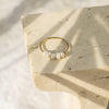 Gold ring with pearls on a stone surface