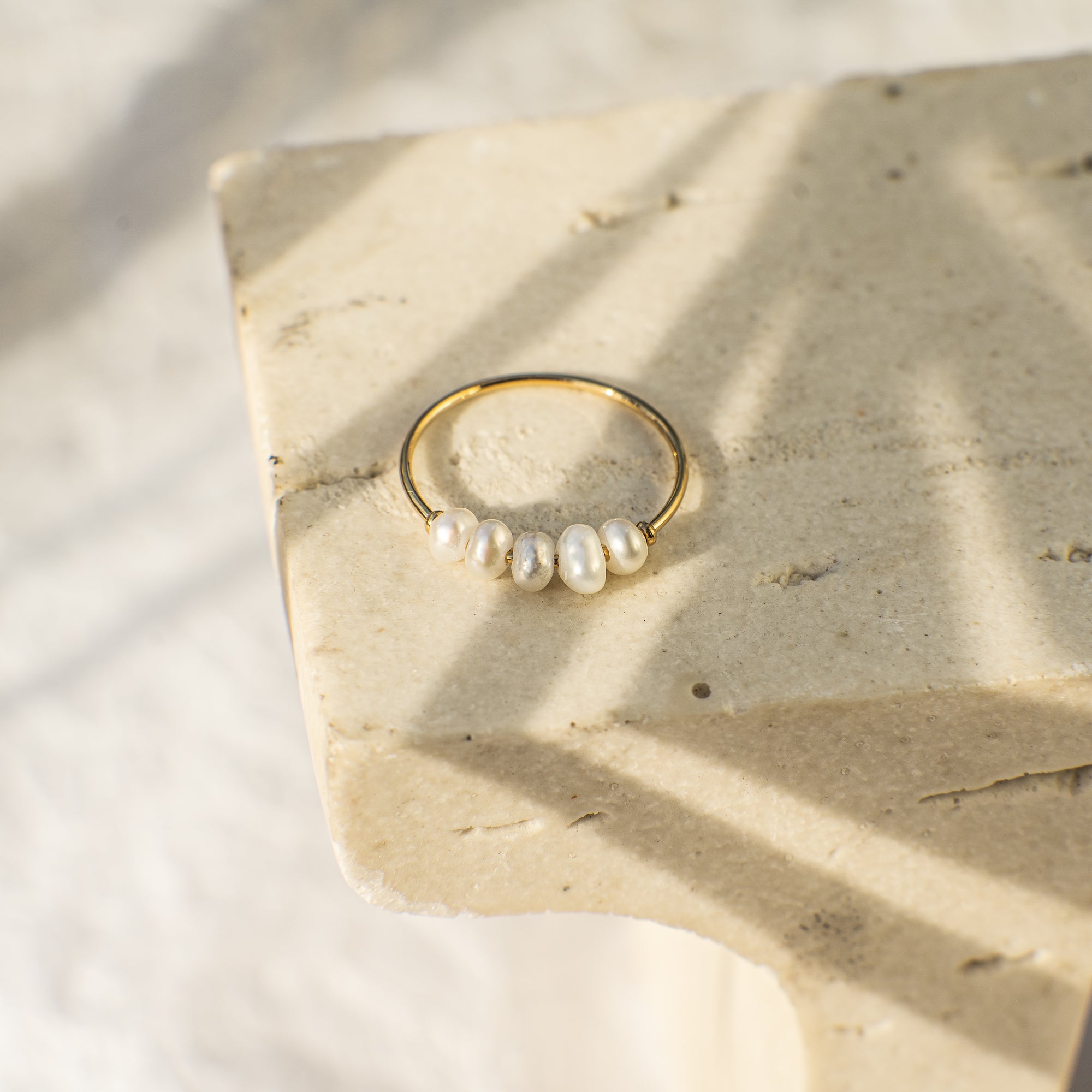 Gold ring with pearls on a stone surface