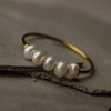 Gold ring with pearls on a textured surface