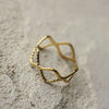Gold ring with geometric design on a textured surface