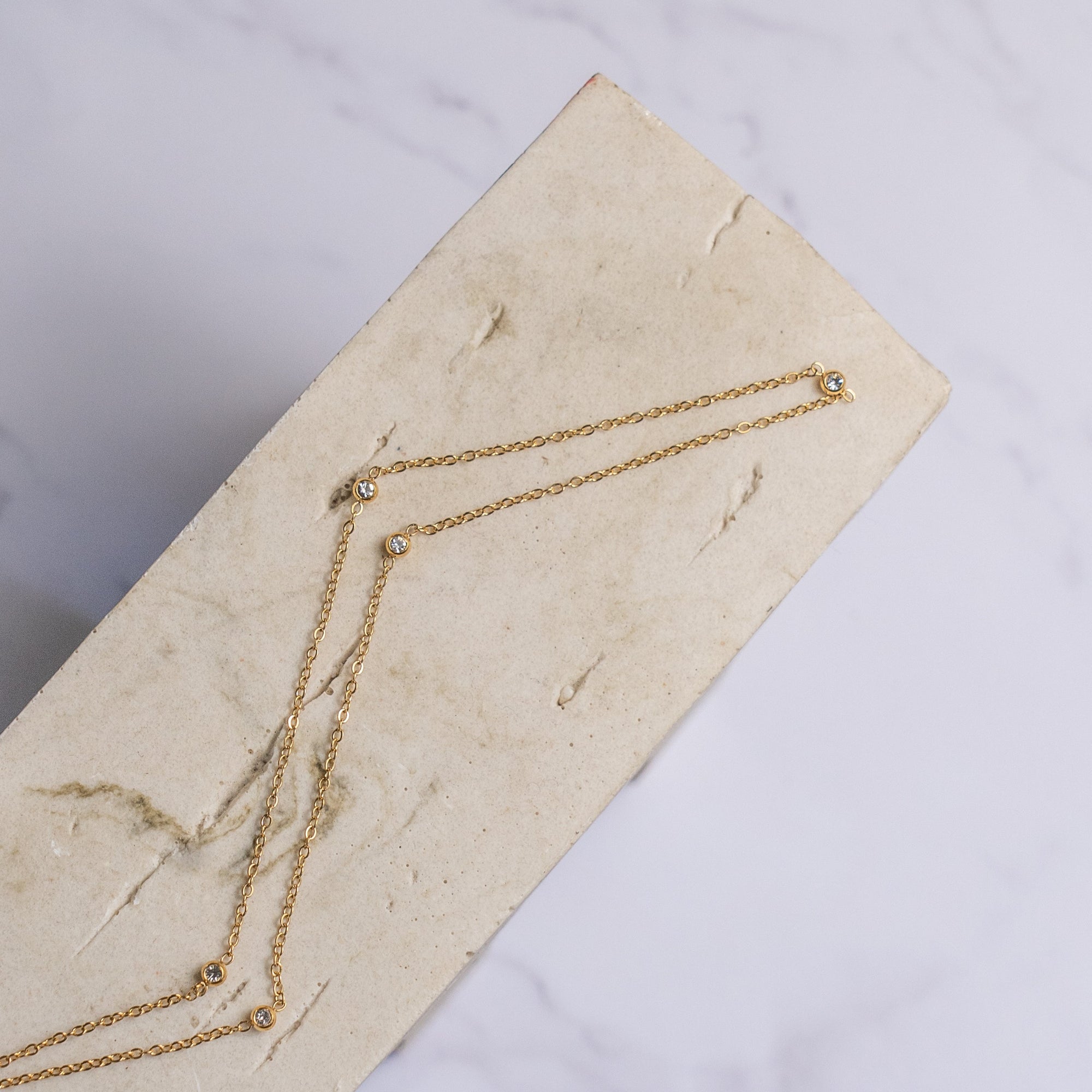 Dorota Zirconia Gold Necklace on a wooden surface