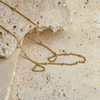Gold chain necklace on a textured beige surface