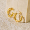 Gold twisted hoop earrings with a playful, twirly design.