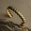 Gold ring with textured design on a stone surface