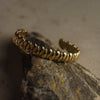 Gold bracelet on a textured stone surface