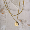Gold necklace with a star pendant on a textured stone surface