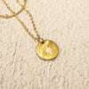 Gold necklace with a star pendant on a textured beige background