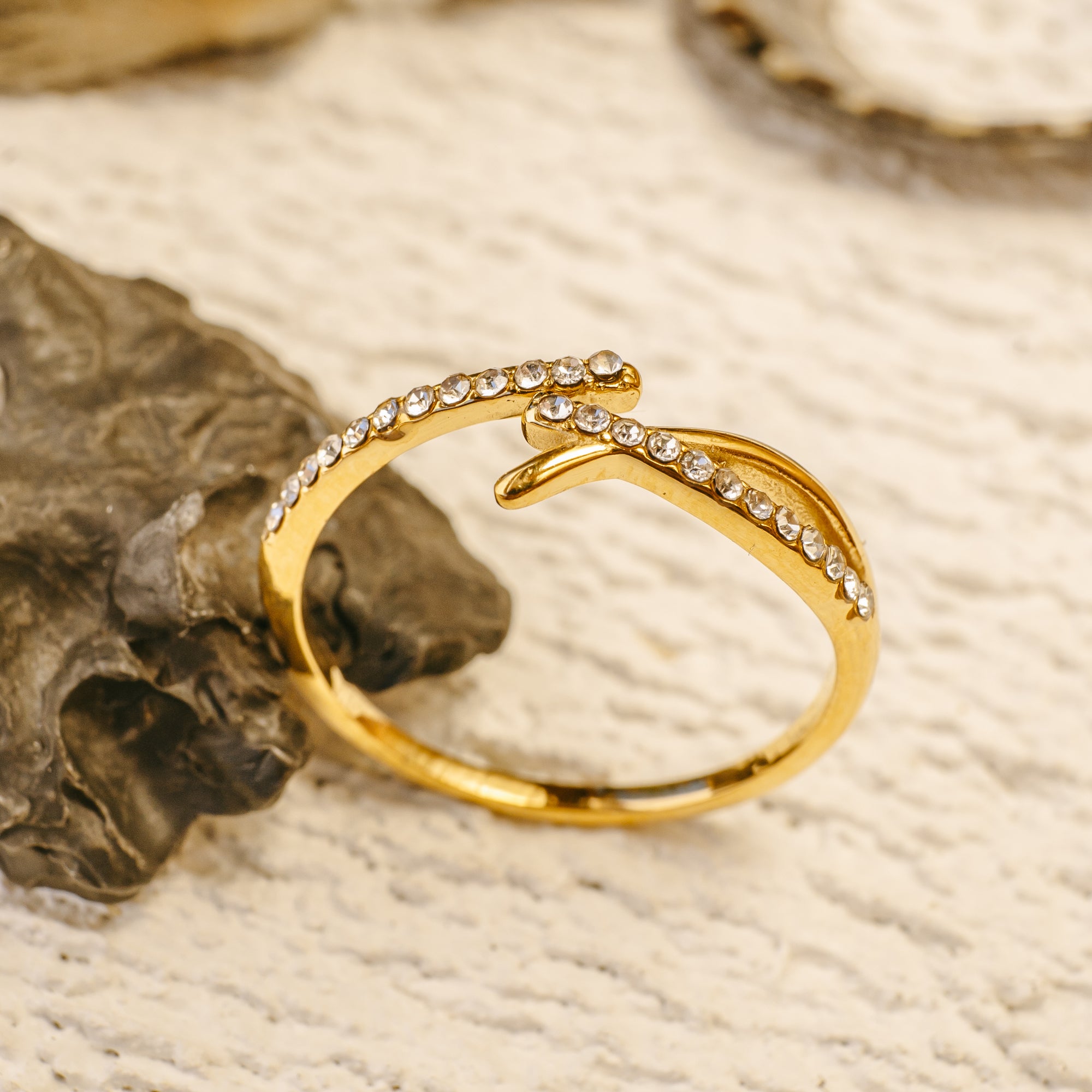 Gold ring with diamond accents on a textured surface
