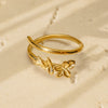 Gold ring with floral design on a beige background