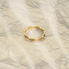 Gold ring with small diamonds on a marble surface