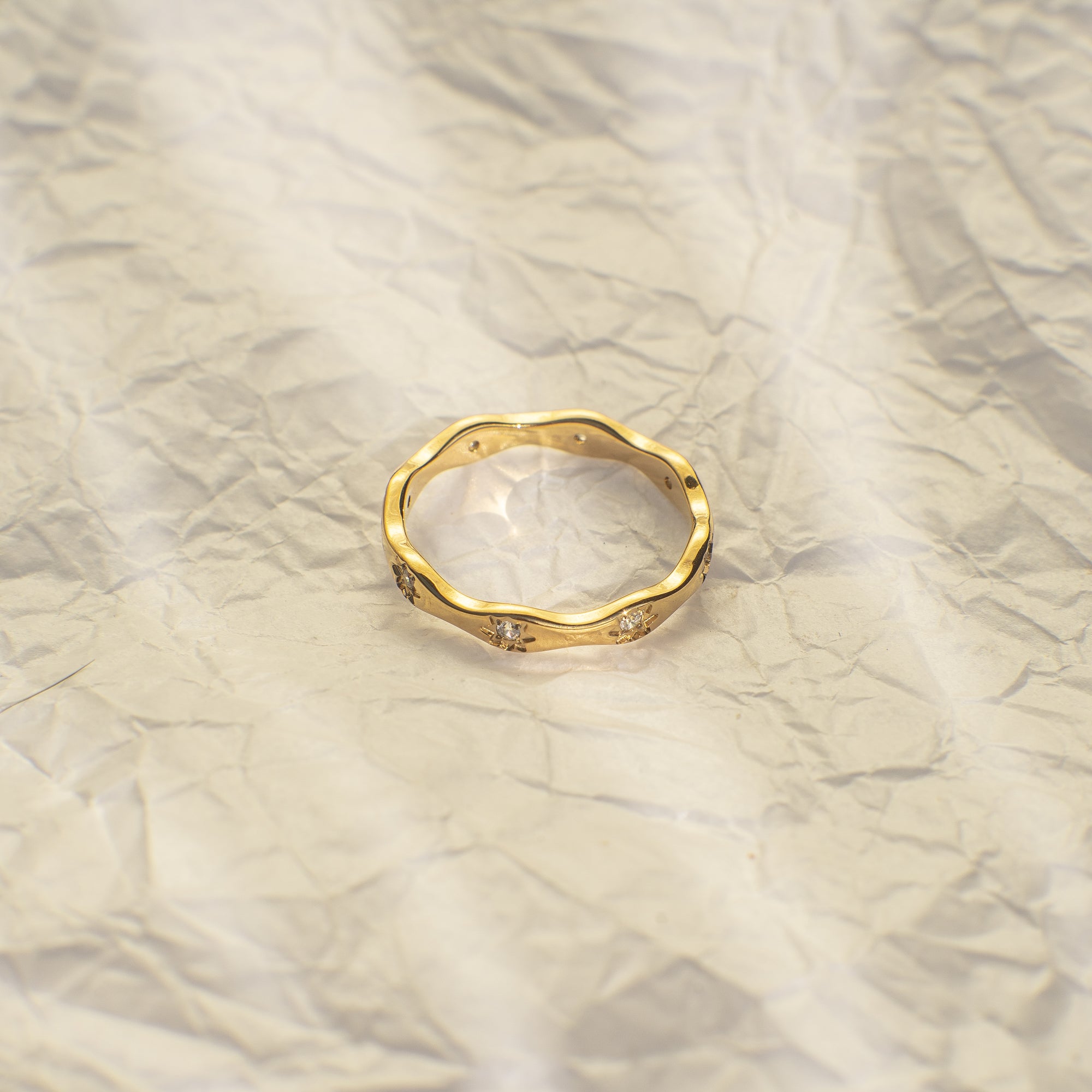 Gold ring with small diamonds on a marble surface